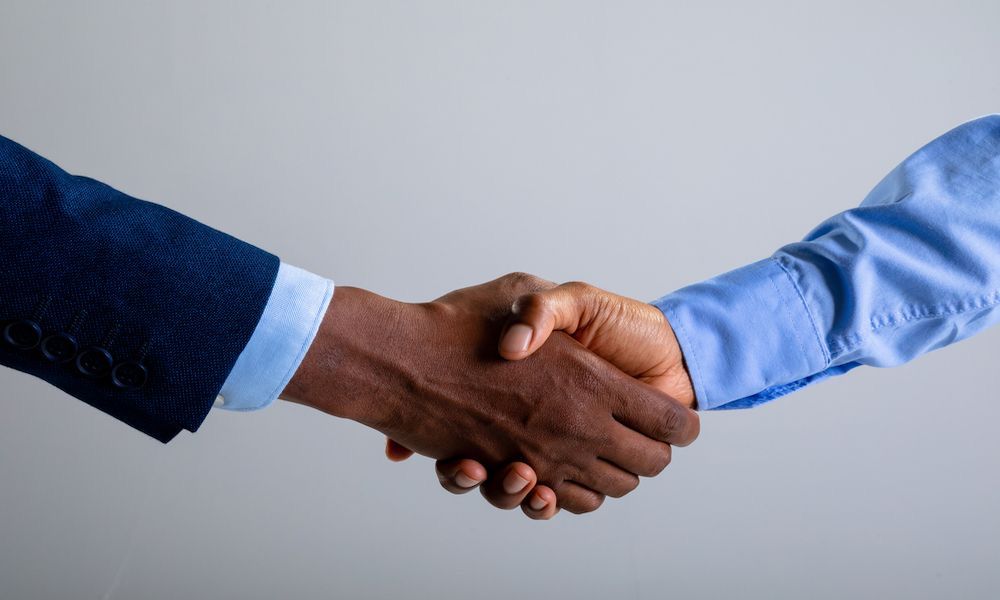 Poignée de main entre deux professionnels, illustrant les cartes NFC du Pack Entreprise