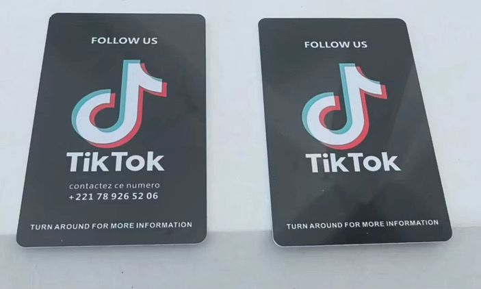 Deux cartes NFC à un réseau noires au logo TikTok, portant « Follow us »